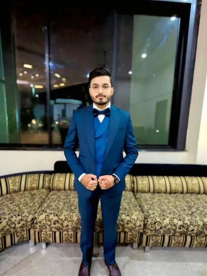 A full-length shot of the groom in his blue three-piece suit. The fit of the suit and the polished grooming come together for a very dapper look.