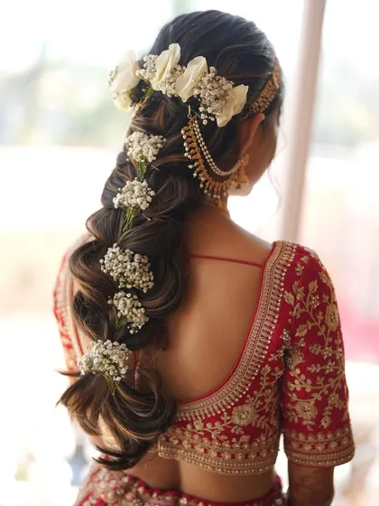 A bridal hairstyle should be a work of art. Here, I've created an intricate floral braid for a Pahadi bride, weaving in fresh flowers to create a unique and stunning look from every angle.