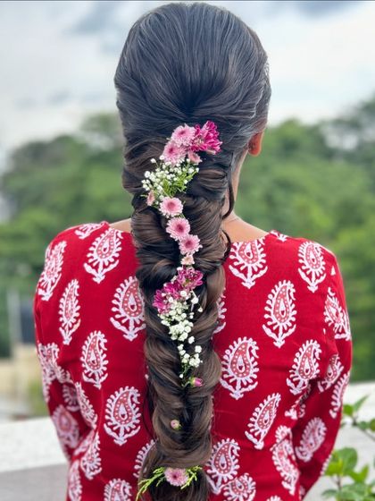A closer look at the floral fishtail braid, showing the intricate weaving of the braid and the careful placement of each flower.