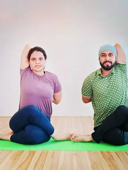Practicing Gomukhasana (Cow Face Pose) with a student. This pose is excellent for opening tight shoulders and hips, and we often practice it in pairs for symmetry.