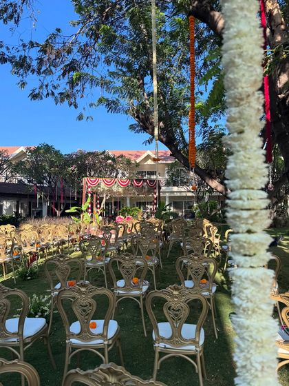A view from the back of the wedding ceremony, showing the elegant seating arrangement and the beautifully decorated mandap in the distance.