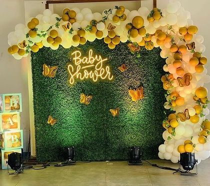 A clear view of the green wall backdrop for the baby shower, perfect for photos. The setup includes 'BABY' blocks and spotlights.