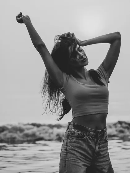 A powerful and expressive pose in black and white. The high contrast between the sky and the model creates a dramatic silhouette.