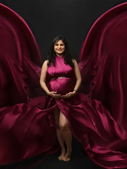 A portrait that embodies power and grace. The rich magenta gown flows like wings, creating a dynamic and visually stunning image that celebrates the strength of motherhood.