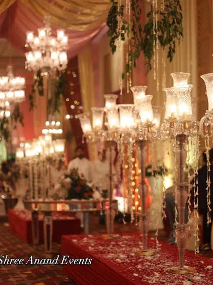 A row of crystal candelabras lining a red carpet, their light reflecting beautifully and creating a path of elegance.