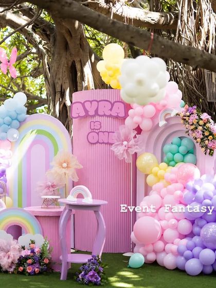 Another angle of Ayra's rainbow butterfly party, highlighting the beautiful blend of pastel colors, the "AYRA IS ONE" sign, and the creative use of balloon art.