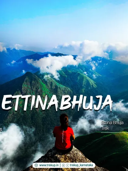 A trekker sitting atop Ettinabhuja peak, overlooking a sea of clouds. A truly breathtaking view.