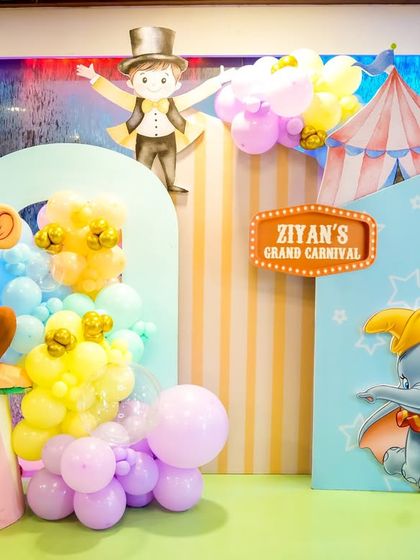 A charming photo spot featuring Dumbo and a monkey prop against a pastel carnival backdrop.