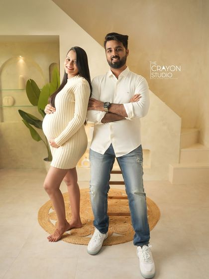 A classic couple shot showing off their excitement. The neutral tones of their outfits and the studio's decor create a chic and timeless look.