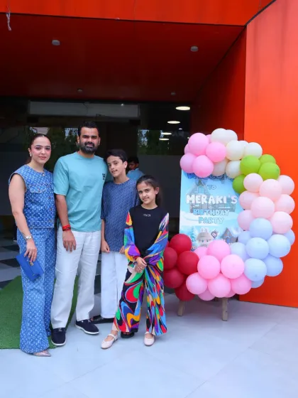 A family arrives at the Labubu-themed birthday party, greeted by a personalized welcome sign.