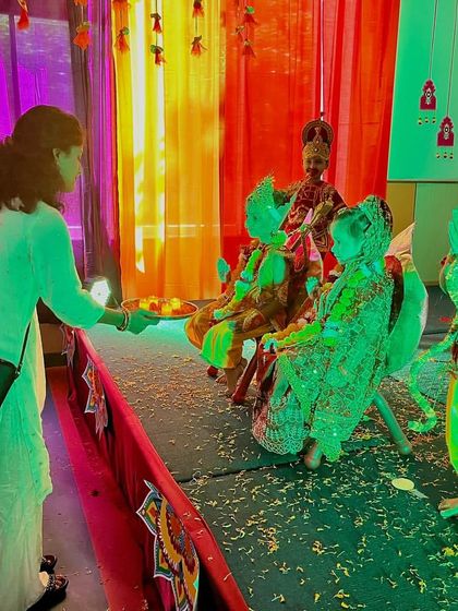 A parent performs aarti for students dressed as characters from the Ramayana during our Dussehra celebration.