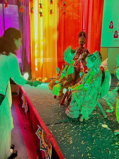 During our Dussehra event, a teacher performs the 'aarti' for students dressed as characters from the Ramayana, blending tradition with performance.