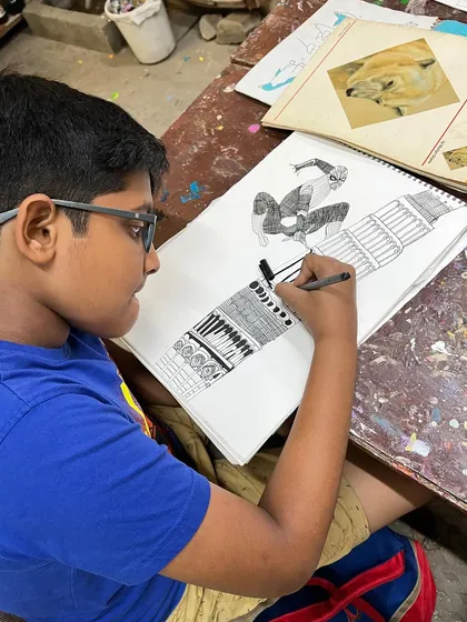 A student works on a detailed pen and ink drawing featuring Spiderman on the Qutub Minar, combining pop culture with famous landmarks.