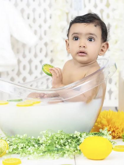 A beautiful, calm moment during a milk bath session, with the baby looking thoughtfully at the camera.