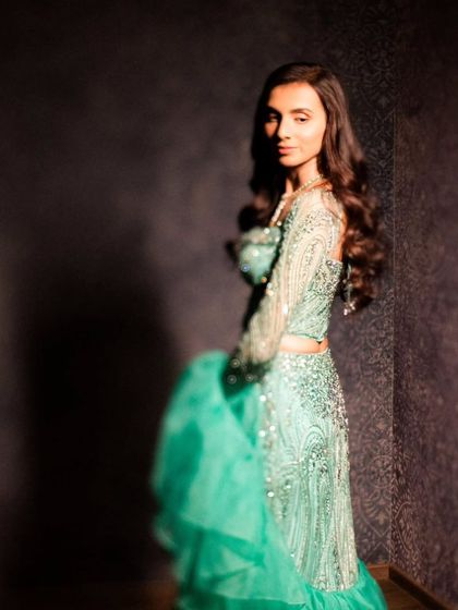 A solo portrait of the bride, her expression serene and captivating, captured in a softly lit, intimate setting.