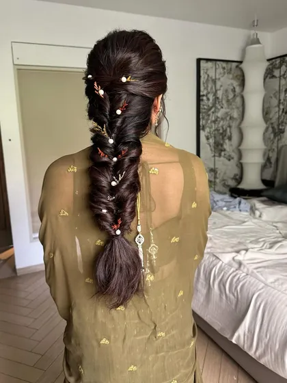 A look at the beautiful, detailed fishtail braid adorned with pearls. This hairstyle is the perfect complement to her elegant Mehendi look.