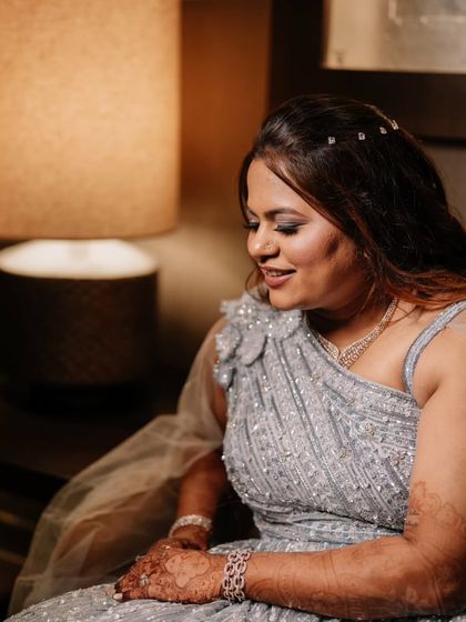 A quiet, contemplative moment. The soft lighting highlights the beautiful details of her gown and the elegant, understated makeup.