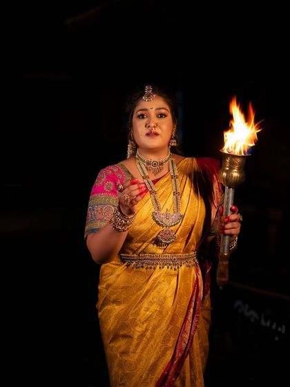 A dramatic, low-key portrait from the "Belaku" shoot, where the flame is the primary light source, creating deep shadows and a sense of mystery.