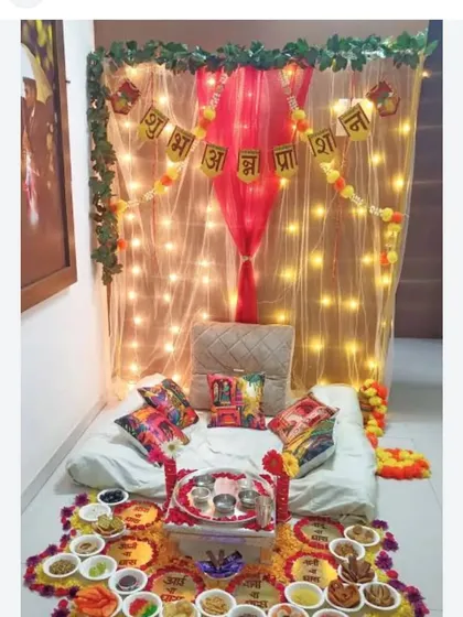 This is a traditional setup for an Annaprashan ceremony, the baby's first rice-eating ritual. I created a cozy seating area with a decorative backdrop, fairy lights, and marigold flower arrangements.