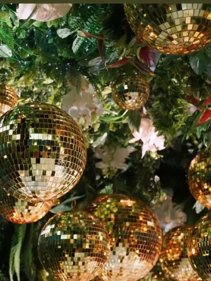 Decor is incomplete without looking up. A ceiling installation of disco balls mixed with greenery adds a layer of glamour and fun to the entire party space.