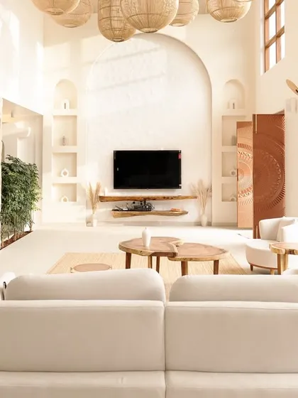 Stepping inside the Artha Villa, the double-height living space is flooded with natural light. I used a palette of whites, natural wood, and woven rattan lighting to create an airy, open-concept interior that feels both grand and deeply calming.
