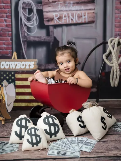 A close-up of our adorable cowboy in his little red wagon, ready for a wild west adventure.