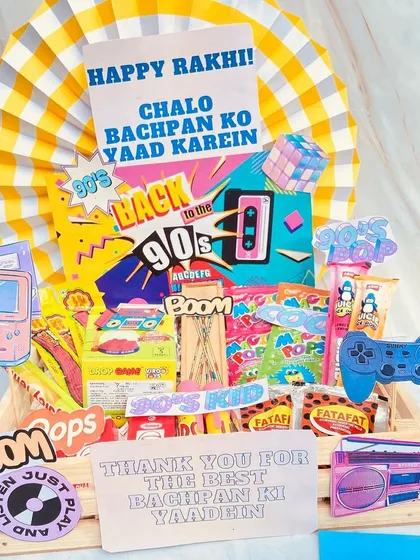 A throwback to the good old days with our 90s kid themed Rakhi hamper. Packed with nostalgic candies, snacks, and retro game-themed cutouts, it's the perfect way to remind your sibling of your shared childhood memories.