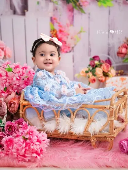 A beautiful baby girl in a floral setting. The soft colors and her sweet smile create a classic and timeless portrait.