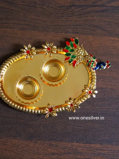 This gold-plated tray with a peacock design and two small bowls is a perfect haldi-kumkum platter. It is a beautiful and useful gift for any married woman.
