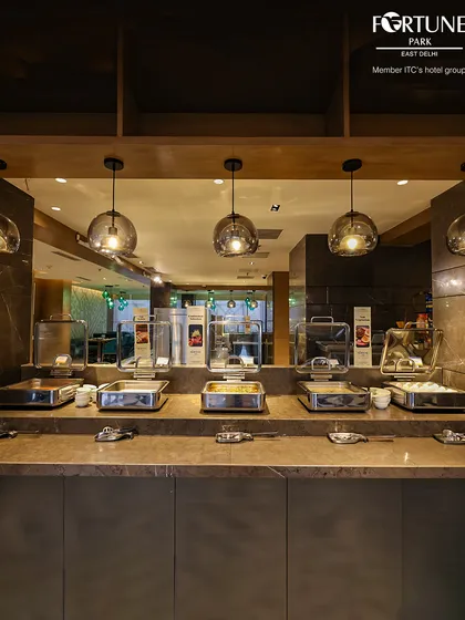 The hot section of our buffet, with dishes kept warm in elegant chafing dishes under modern globe lighting.