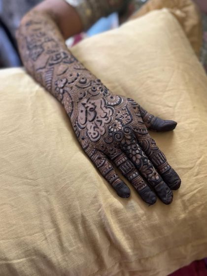 This design features a name written in beautiful Arabic calligraphy, making it a central and artistic part of the henna.