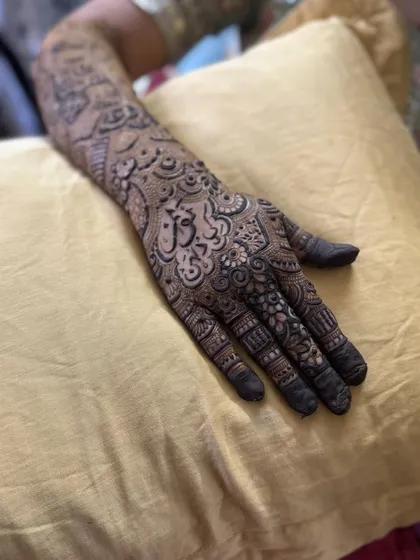 This design features a name written in beautiful Arabic calligraphy, making it a central and artistic part of the henna.