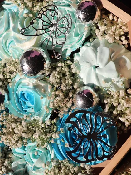 A detailed macro shot of the silver butterfly and floral details on these custom cupcakes.