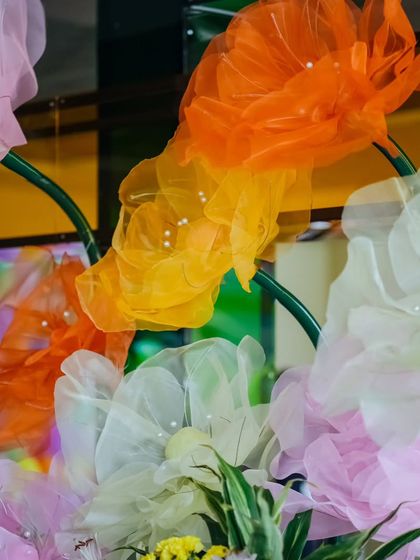 A close-up of the oversized, handcrafted fabric flowers used in the Haldi decor. The delicate, translucent material and pearl centers add a touch of fantasy.
