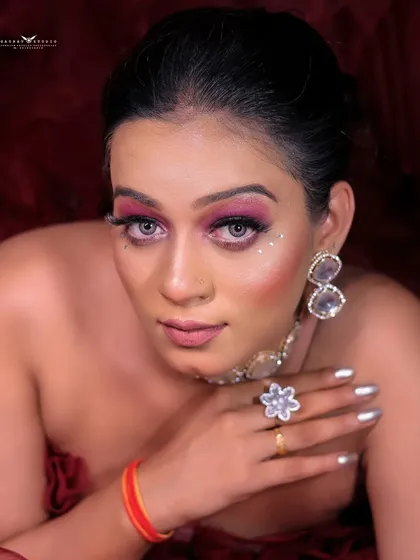A close-up portrait capturing the model's direct gaze and the striking details of her makeup.