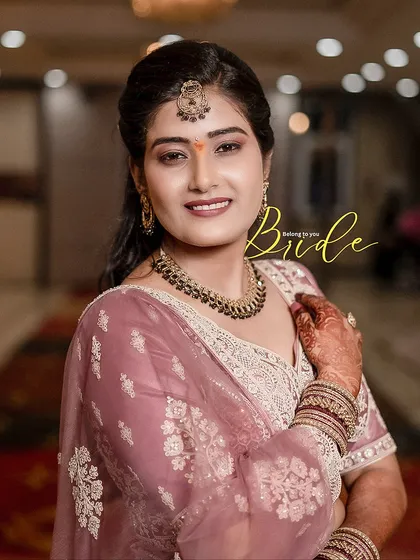A beautiful close-up portrait of the bride, Deepa, showcasing her gentle smile and the intricate embroidery on her outfit.