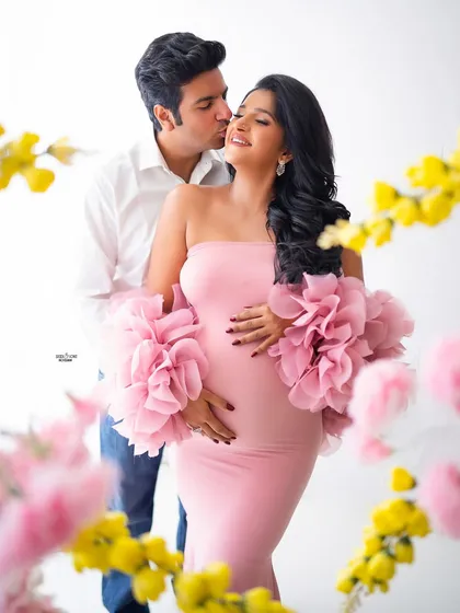 A sweet couple's kiss, framed by a ring of pretty pink and yellow flowers. This is romance overload.