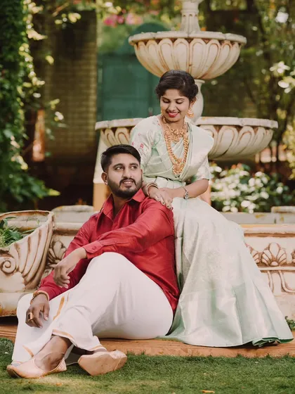 A relaxed and romantic pose by the fountain. The bride's beautiful jewelry and silk saree are highlighted in this lovely pre-wedding photograph.