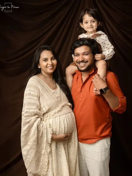 A classic family pregnancy portrait. Having the big sister-to-be on her dad's shoulders adds a playful and loving touch to this beautiful family memory.