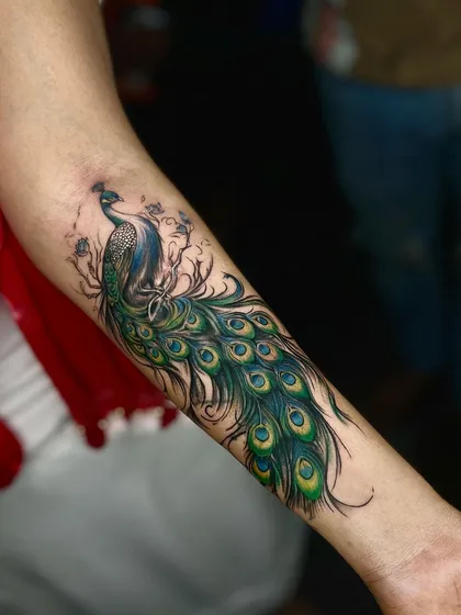 We love working with color, and this peacock forearm tattoo is a great example. The vibrant greens and blues bring the design to life, creating a beautiful and eye-catching piece that flows with the arm's natural shape.