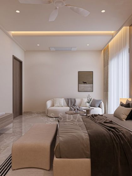 A view of the master bedroom in an upcoming farmhouse villa, showing the seating area with a curved white sofa. The overall aesthetic is minimal yet layered, prioritizing comfort and sophistication.