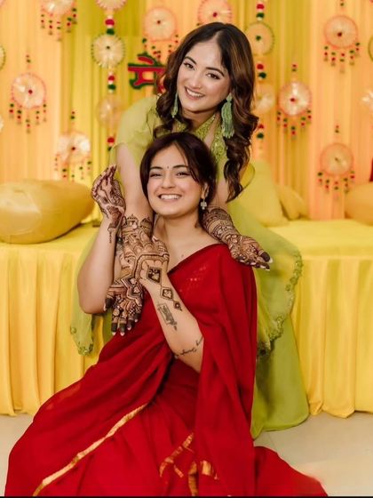 Mehendi is for everyone in the family. A beautiful moment between two sisters, both showing off their henna designs during a family function.