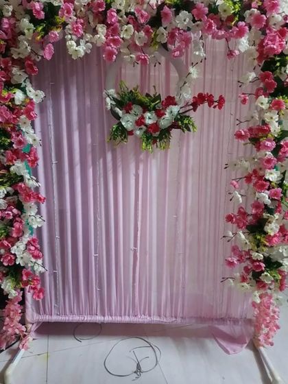 We created this lovely frame using pink and white cherry blossom branches against a soft pink fabric backdrop. A central floral wreath adds a focal point to the design, making it a delicate and charming option for your home.