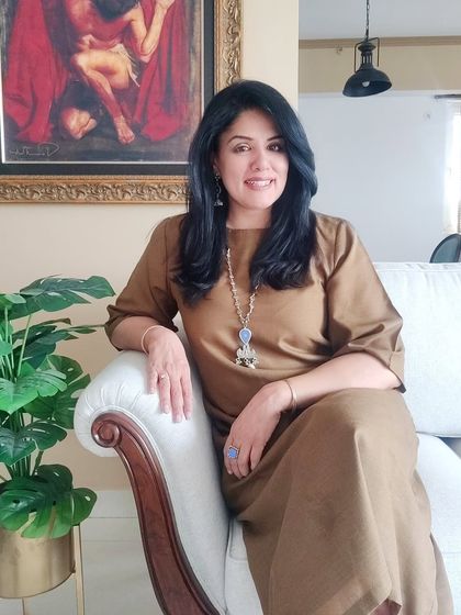 A seated portrait in the brown dress, showing a better view of the statement silver and blue necklace. Don't be afraid to pair unexpected colors together.