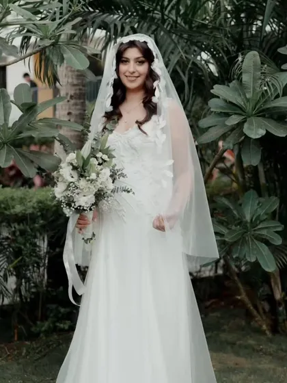 A collection of memories from a beautiful Catholic wedding in Goa. The bride's hair is styled in soft waves under her veil, and her makeup is natural and glowing, capturing her joyful and candid moments perfectly.