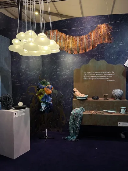 A curated display of objects for the 'Into The Deep' theme. The collection includes sculptures, textiles, and a custom garment, all inspired by the colors and textures of the ocean.