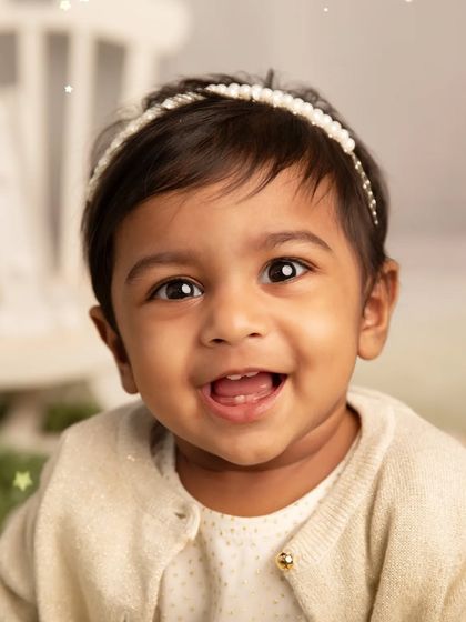 That infectious, toothy grin. This close-up shot is all about capturing the pure, uninhibited happiness of a one-year-old.