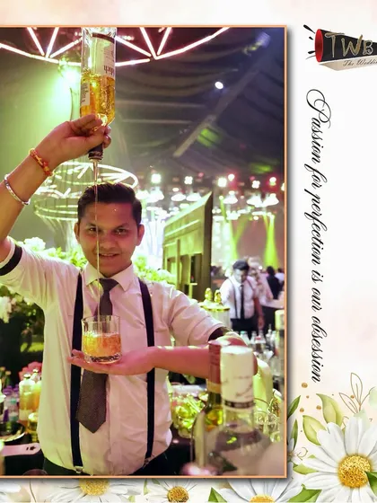 A bartender showcases his flair with a long pour, a technique that aerates the drink while creating a visual spectacle for guests.