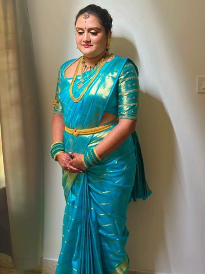 Adithi dressed for her Hase Shastra ceremony in a bright turquoise blue saree with a matching custom blouse.