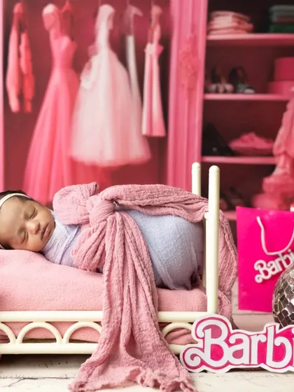 Even the tiniest dolls can join the fun. This newborn is captured sleeping peacefully in a miniature bed within the Barbie dream world setup.